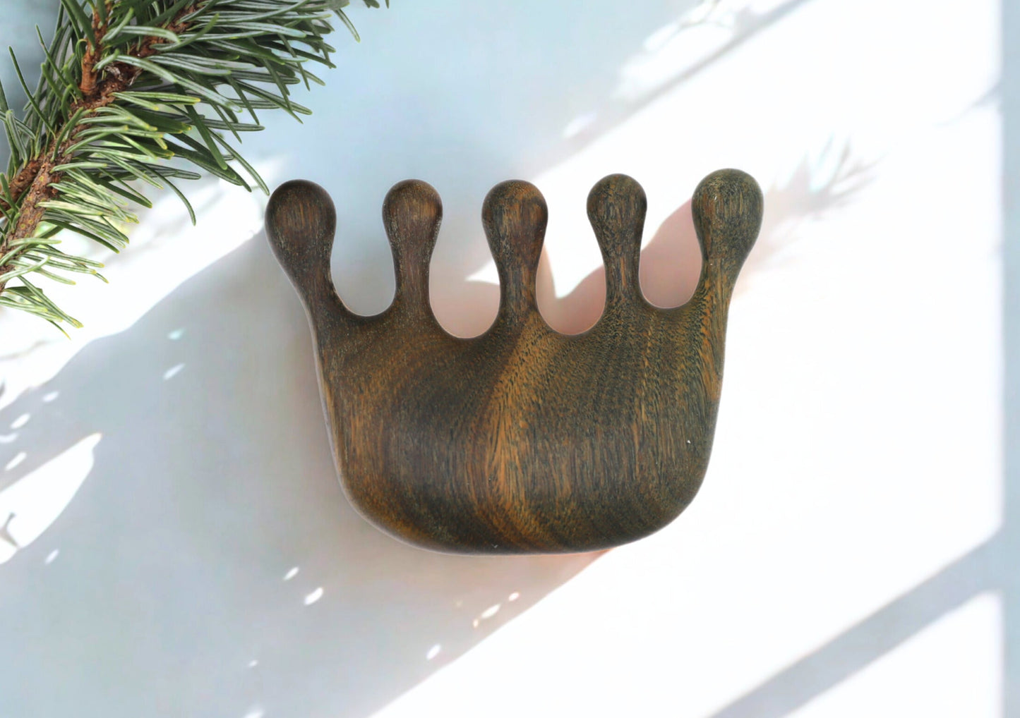 Handcrafted verawood scalp massager with ergonomic curve and five rounded prongs