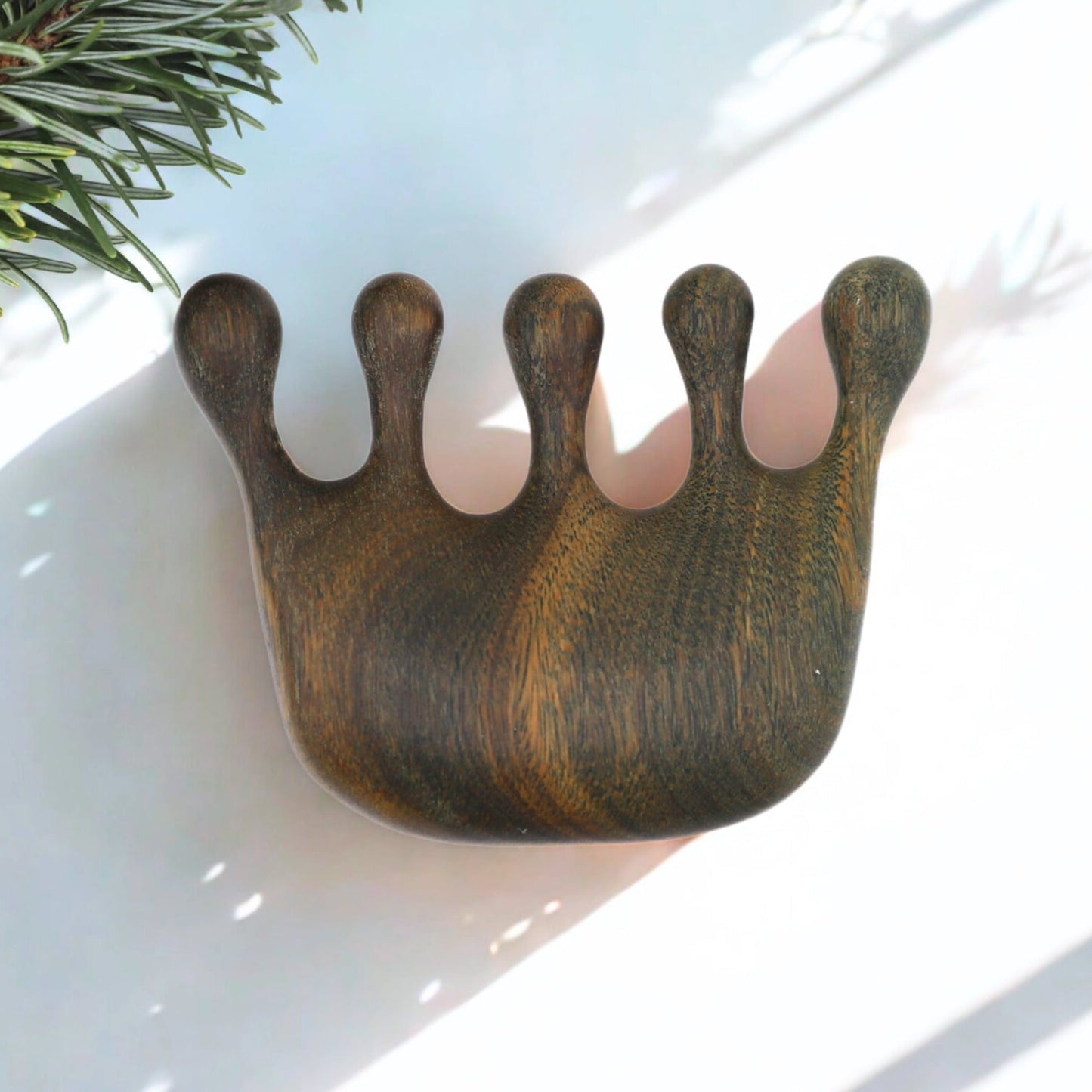 Handcrafted verawood scalp massager with ergonomic curve and five rounded prongs