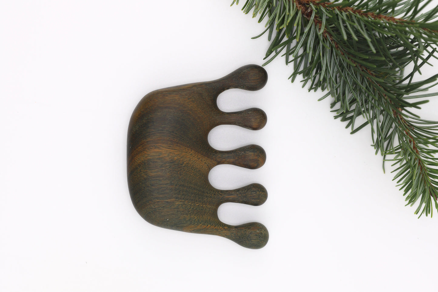 Eco-friendly scalp comb made from dense natural verawood wood grain close-up